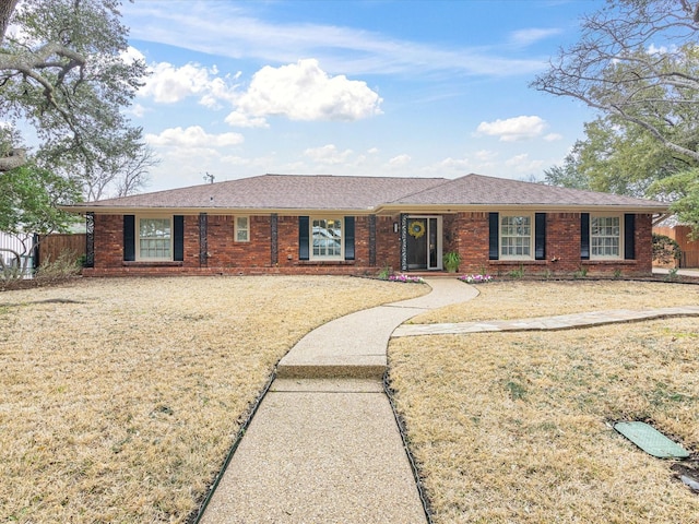 single story home with a front yard, fence, and brick siding