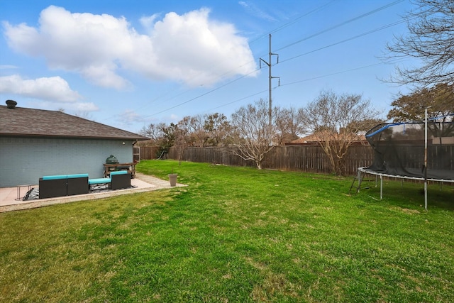 view of yard with a trampoline and a fenced backyard