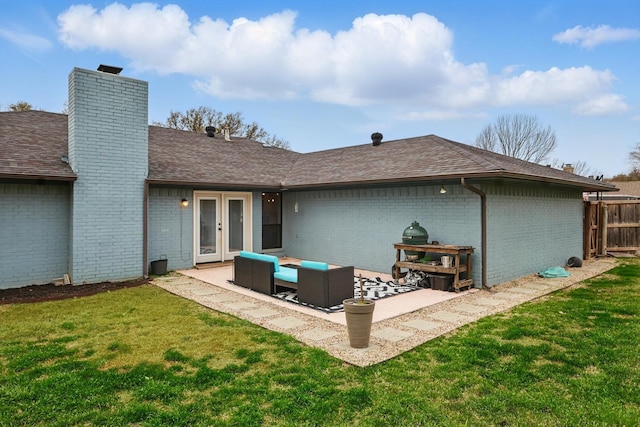 back of property with brick siding, a lawn, a chimney, and a patio