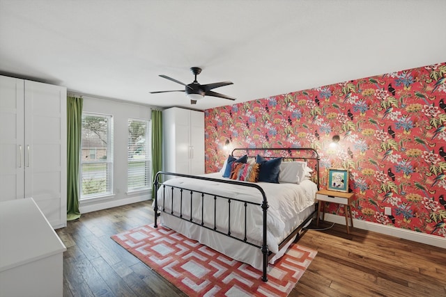 bedroom with wood finished floors, ceiling fan, baseboards, and wallpapered walls