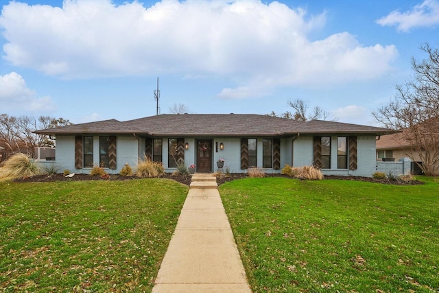 single story home featuring a shingled roof, a front lawn, and brick siding