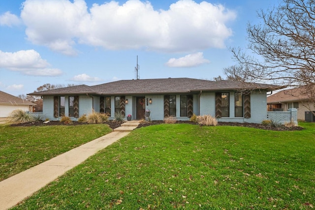 view of front of house featuring brick siding, a front lawn, and cooling unit