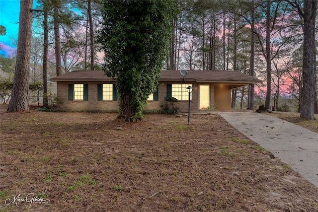 ranch-style house featuring a carport and concrete driveway