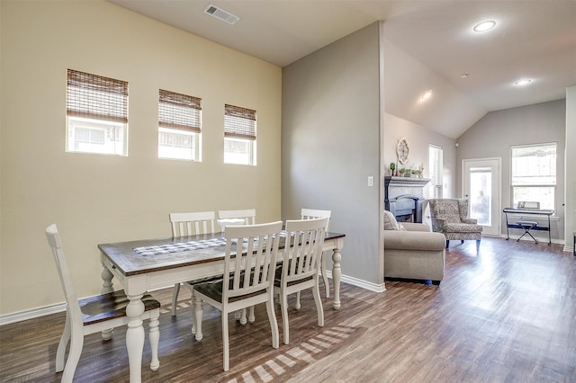 dining area featuring visible vents, a fireplace, baseboards, and wood finished floors