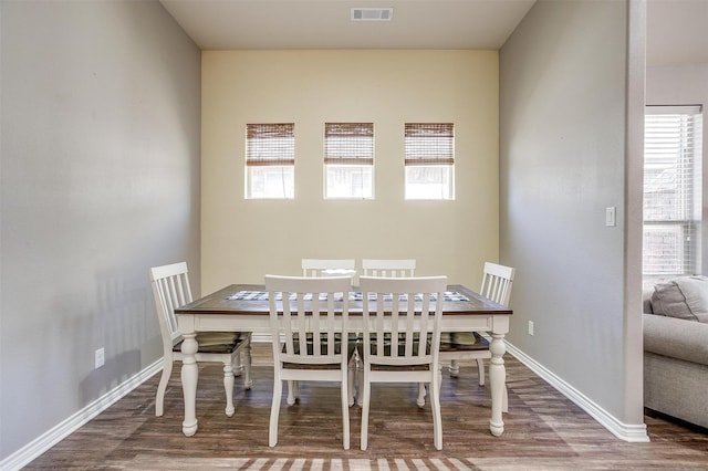 dining area featuring visible vents, baseboards, and wood finished floors