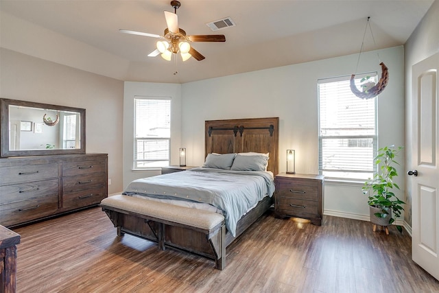 bedroom featuring dark wood-type flooring, multiple windows, visible vents, and baseboards