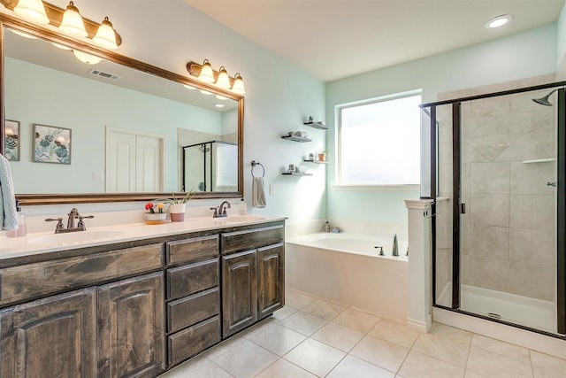 full bathroom with double vanity, tile patterned flooring, a sink, and a shower stall