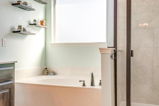 bathroom featuring a stall shower and a bath