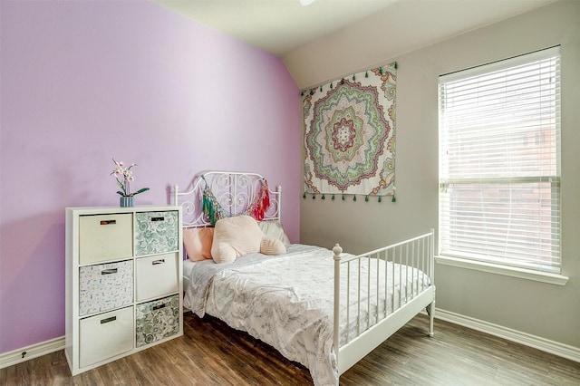 bedroom featuring multiple windows, wood finished floors, and baseboards