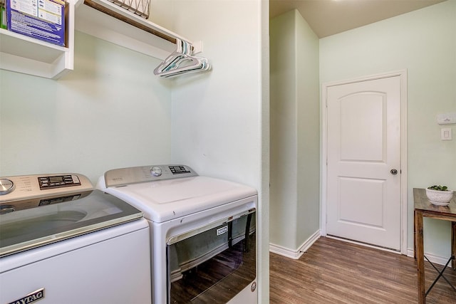 washroom featuring baseboards, laundry area, wood finished floors, and washer and dryer