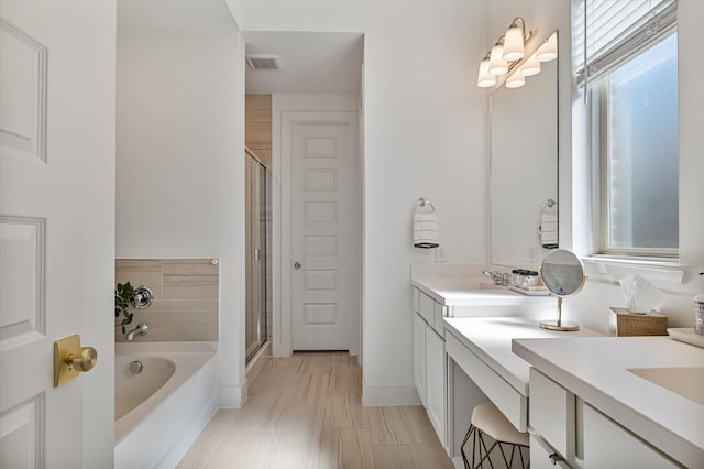 bathroom featuring visible vents, a stall shower, vanity, and a bath