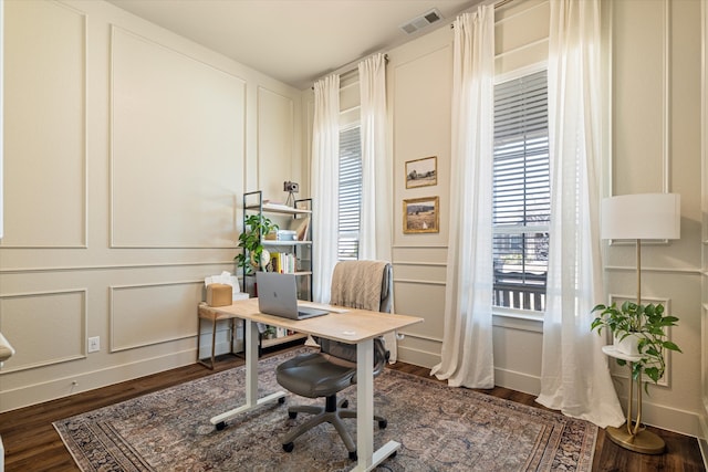 office with visible vents, baseboards, dark wood-style flooring, and a decorative wall