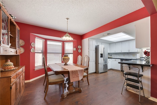 dining room with visible vents, a textured ceiling, baseboards, and dark wood-style flooring