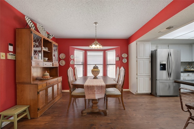 dining room featuring baseboards, dark wood-style flooring, and a textured ceiling