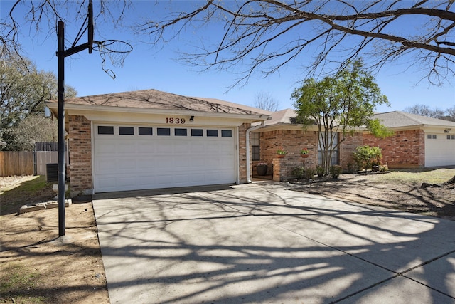 ranch-style house with driveway, fence, an attached garage, brick siding, and central AC unit