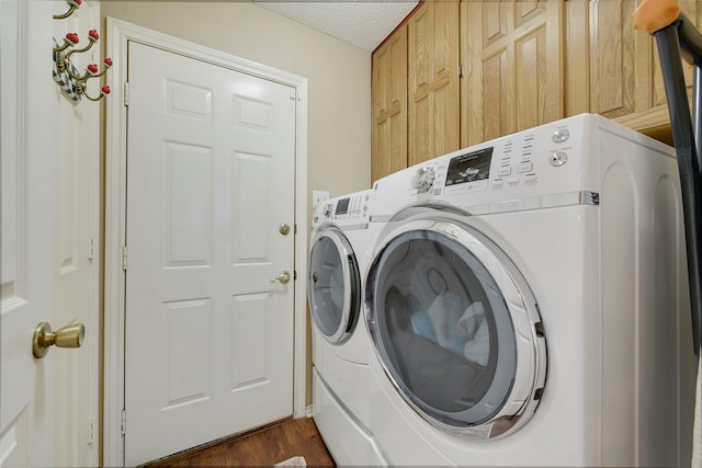 clothes washing area featuring cabinet space, a textured ceiling, independent washer and dryer, and dark wood-style flooring