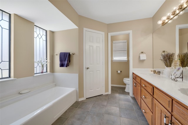 full bathroom featuring baseboards, toilet, double vanity, a bath, and a sink