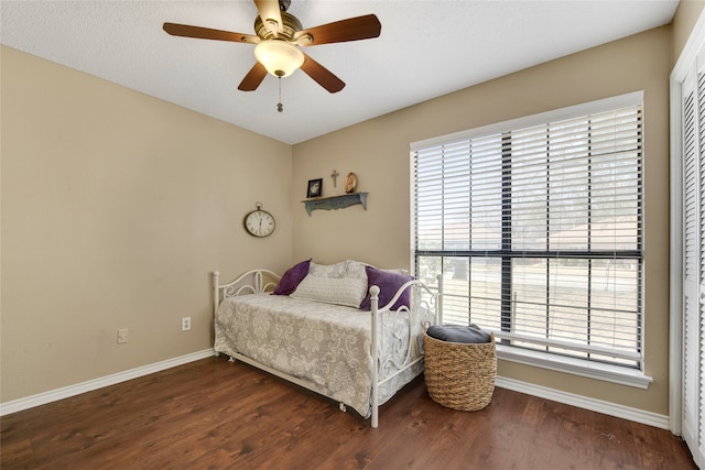 bedroom featuring a closet, ceiling fan, baseboards, and wood finished floors