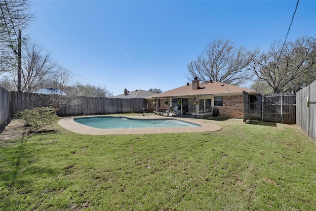 view of swimming pool with a yard, a fenced in pool, and a fenced backyard