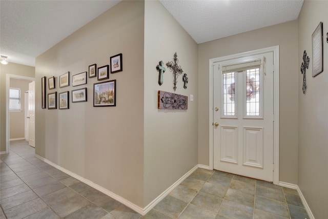 entrance foyer featuring a textured ceiling and baseboards