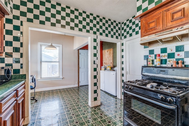 kitchen with black range with gas cooktop, decorative backsplash, dark countertops, washing machine and clothes dryer, and under cabinet range hood