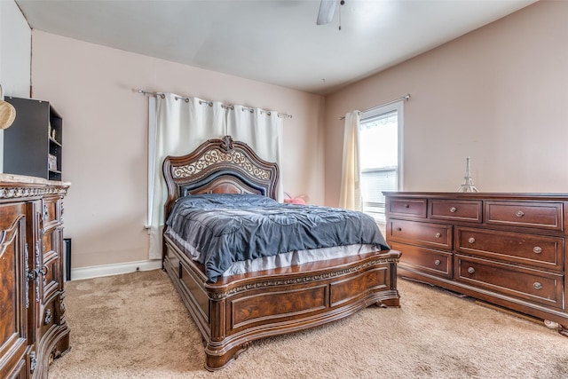 bedroom with a ceiling fan, light carpet, and baseboards