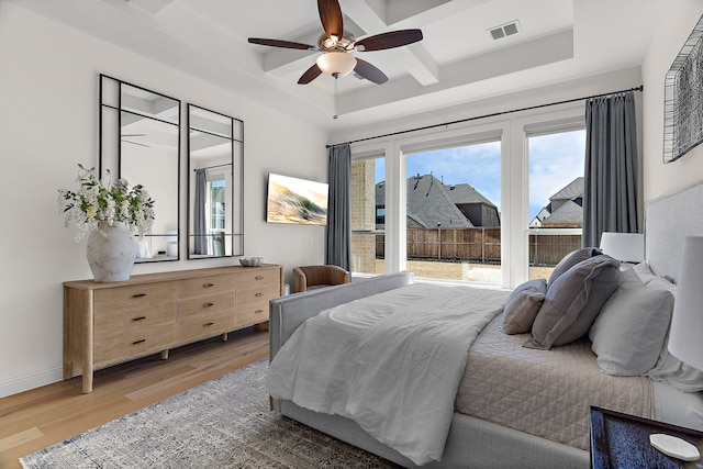 bedroom with visible vents, coffered ceiling, baseboards, light wood-style flooring, and beamed ceiling