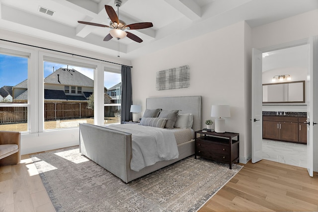 bedroom featuring light wood finished floors, coffered ceiling, visible vents, and baseboards