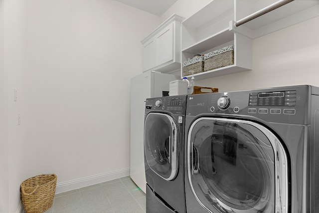 laundry room with laundry area, light tile patterned floors, baseboards, and washer and clothes dryer