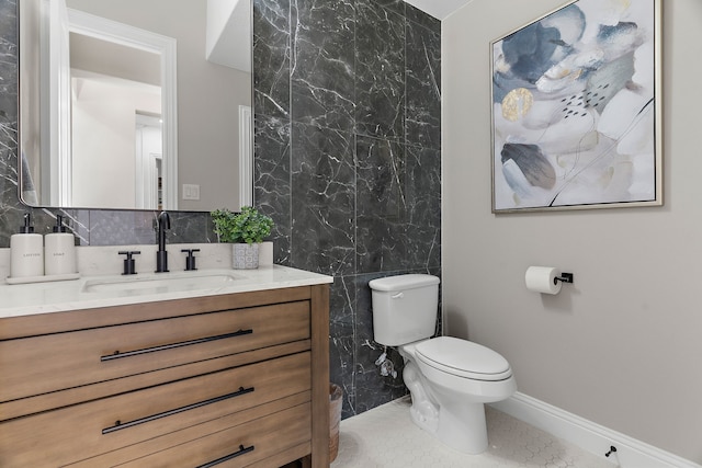 bathroom with baseboards, vanity, toilet, and tile patterned floors