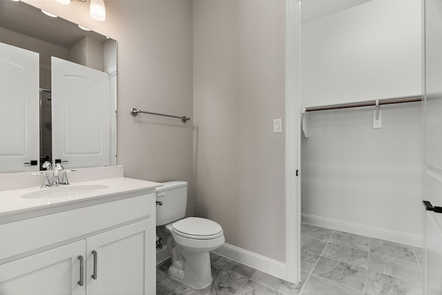 bathroom featuring marble finish floor, toilet, vanity, and baseboards