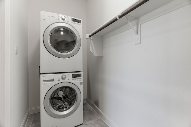 laundry area featuring laundry area, stacked washer and dryer, and baseboards