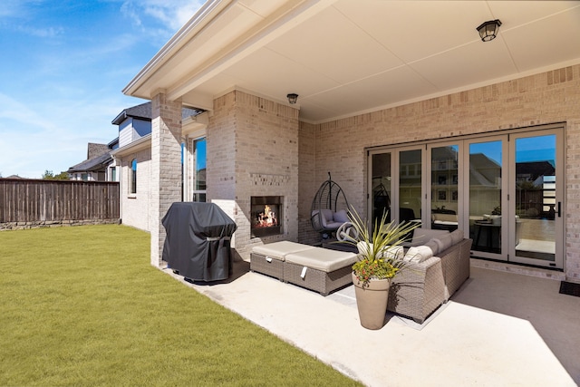 view of patio / terrace with an outdoor living space with a fireplace, fence, and grilling area