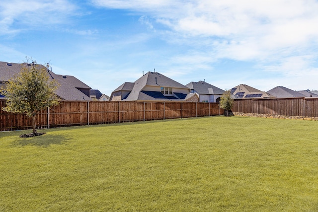 view of yard with a fenced backyard and a residential view