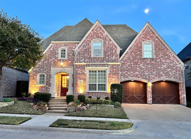 view of front of home featuring concrete driveway, brick siding, and roof with shingles