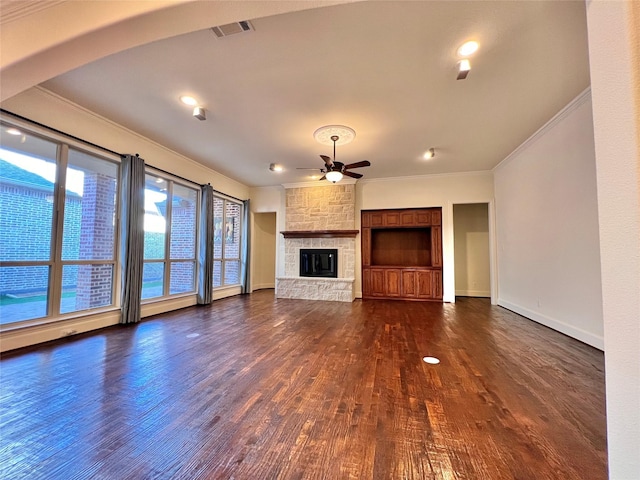 unfurnished living room featuring ceiling fan, a fireplace, visible vents, dark wood-style floors, and crown molding