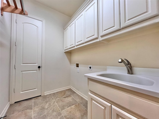 washroom featuring hookup for an electric dryer, washer hookup, a sink, baseboards, and cabinet space