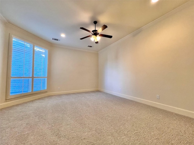 empty room featuring ornamental molding, light carpet, baseboards, and a ceiling fan