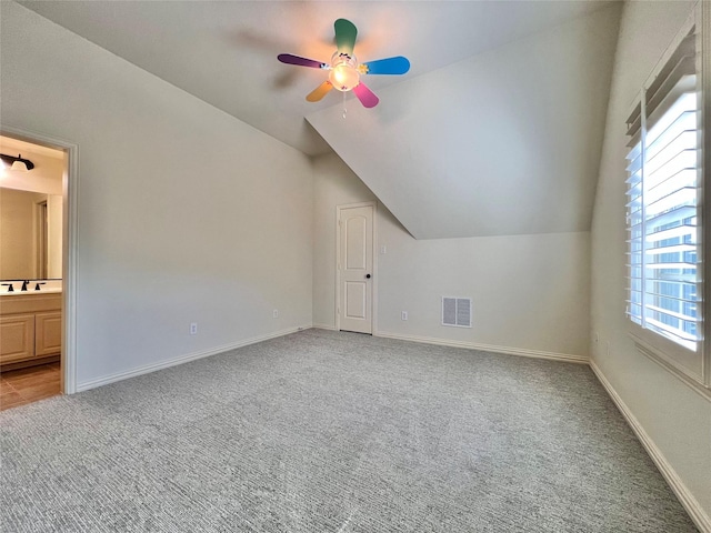 bonus room with lofted ceiling, visible vents, light carpet, a sink, and baseboards