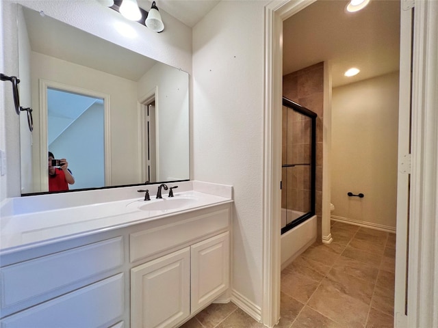 bathroom featuring toilet, recessed lighting, vanity, baseboards, and combined bath / shower with glass door