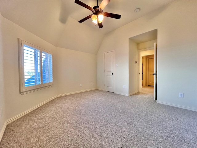 unfurnished bedroom with vaulted ceiling, light carpet, a ceiling fan, and baseboards