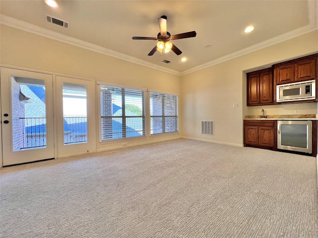 unfurnished living room featuring beverage cooler, light carpet, and visible vents