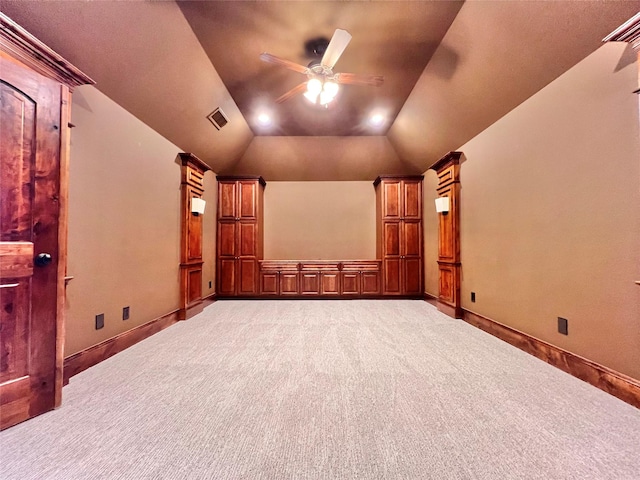 carpeted cinema featuring lofted ceiling, ceiling fan, visible vents, and baseboards