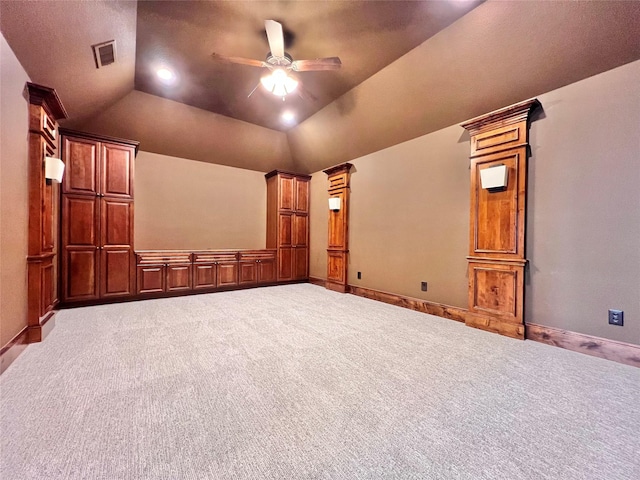 interior space with baseboards, visible vents, vaulted ceiling, and a ceiling fan