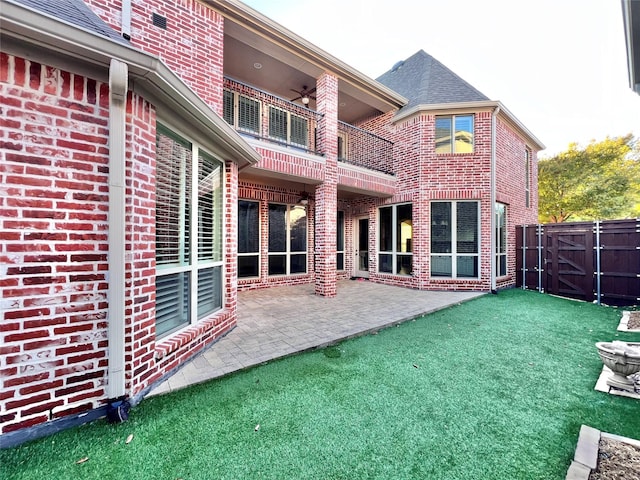 back of property with a patio, brick siding, a balcony, and a ceiling fan