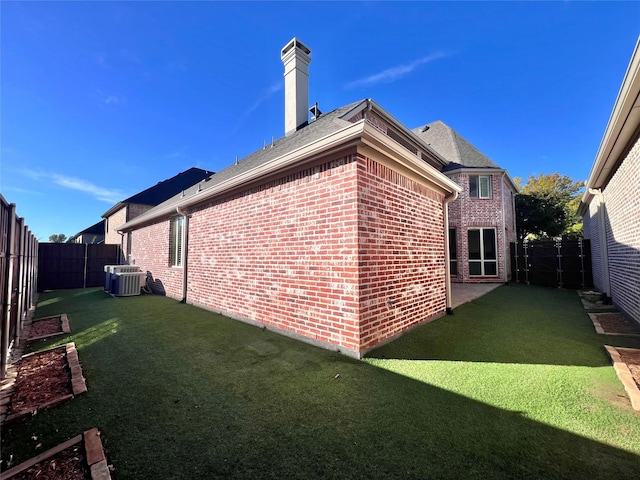 view of property exterior with a fenced backyard, a chimney, central AC unit, and brick siding