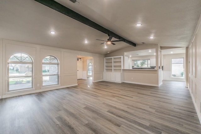 unfurnished living room with vaulted ceiling with beams, recessed lighting, a decorative wall, wood finished floors, and a ceiling fan