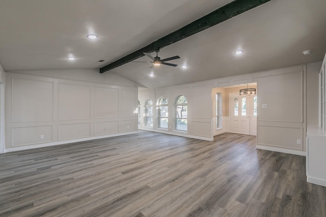 unfurnished living room featuring visible vents, lofted ceiling with beams, ceiling fan, wood finished floors, and a decorative wall