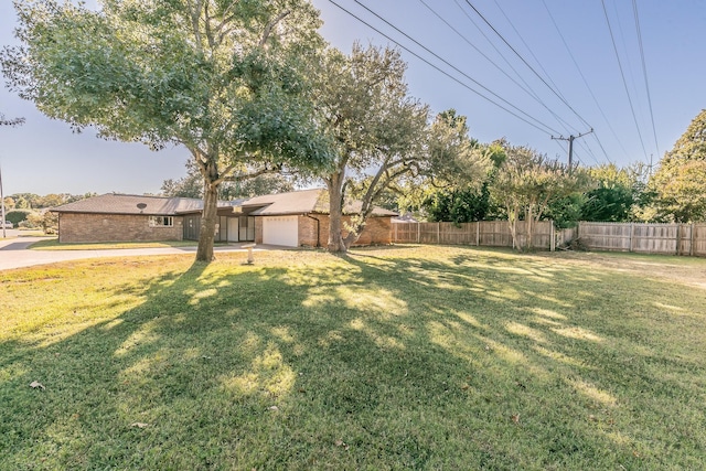 view of yard with an attached garage and fence