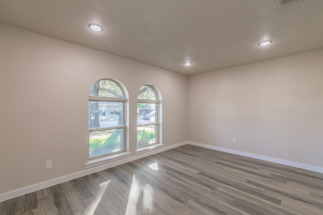 spare room featuring visible vents, baseboards, wood finished floors, and recessed lighting